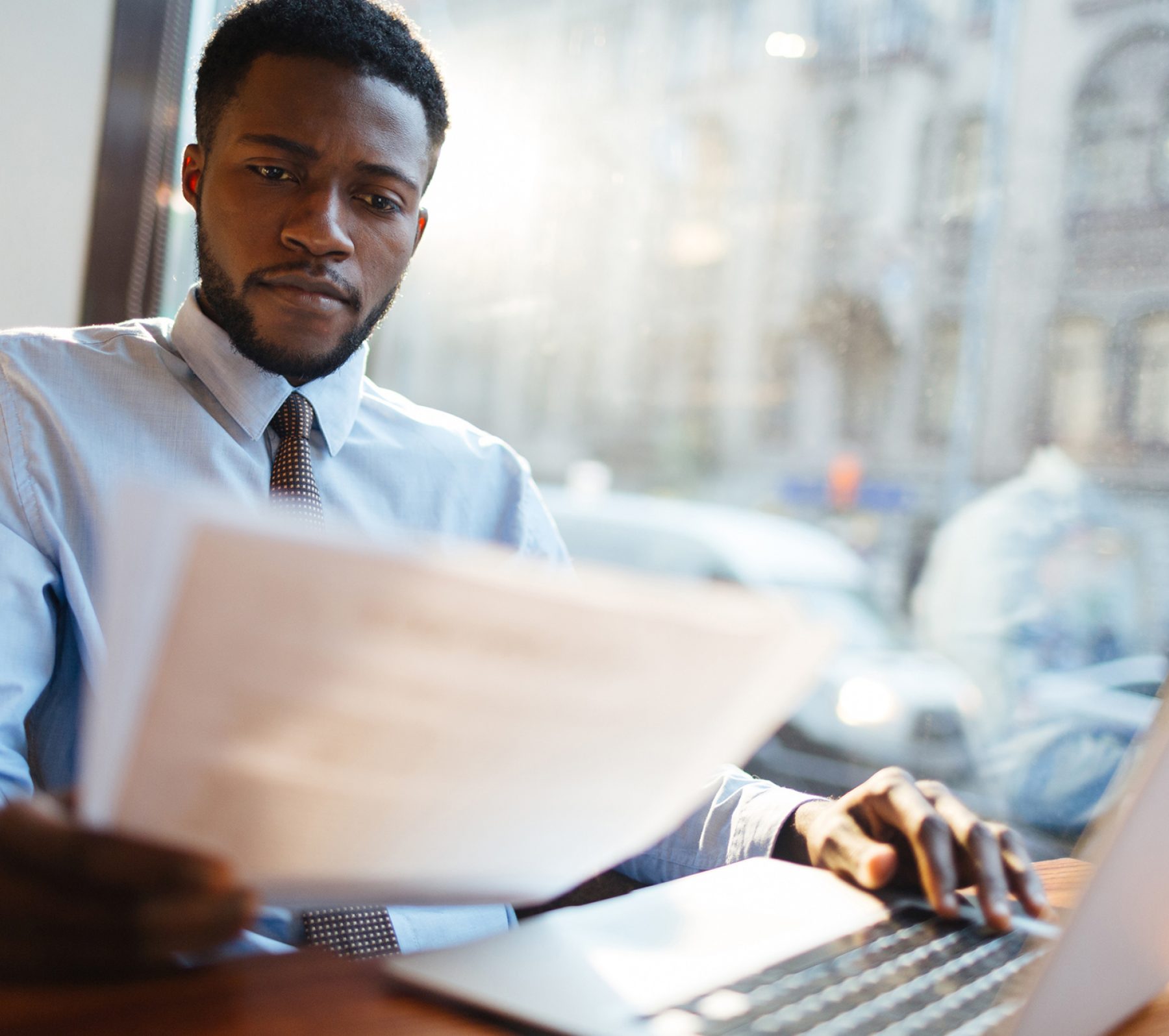 Serious employer reading resumes of candidates for vacancy